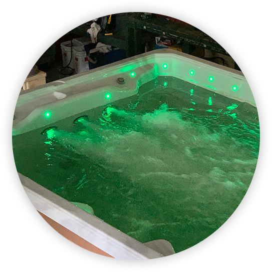 Lit hot tub with green lights and bubbling water.