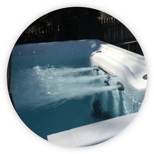 Hot tub with jets spraying water, indoors.