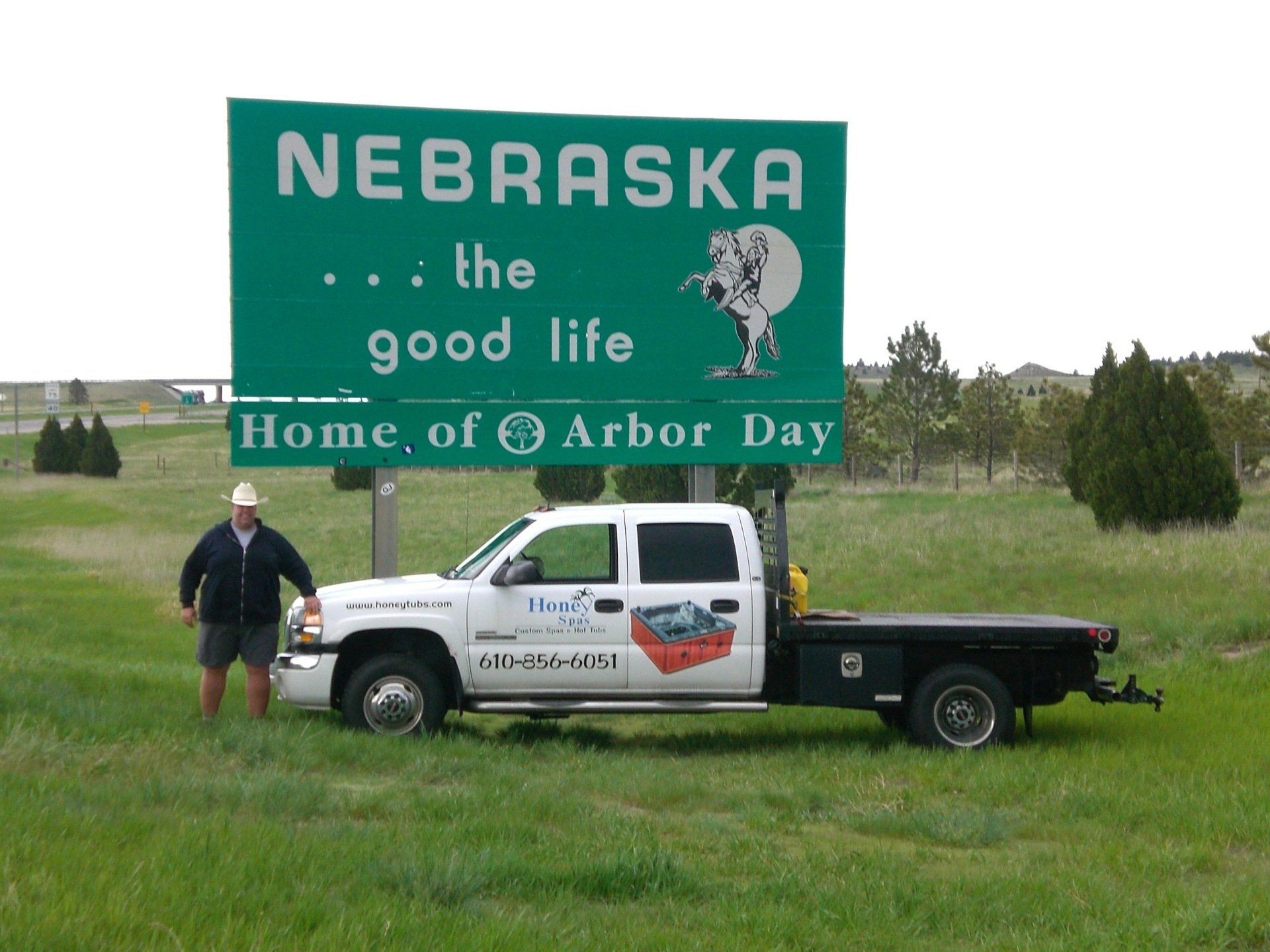 Man stands next to a white pickup truck near a 