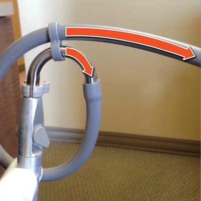 Vacuum cleaner hose with an arrow indicating airflow direction.
