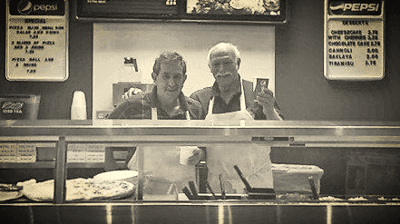 Two men are standing behind a counter with a pepsi sign above them