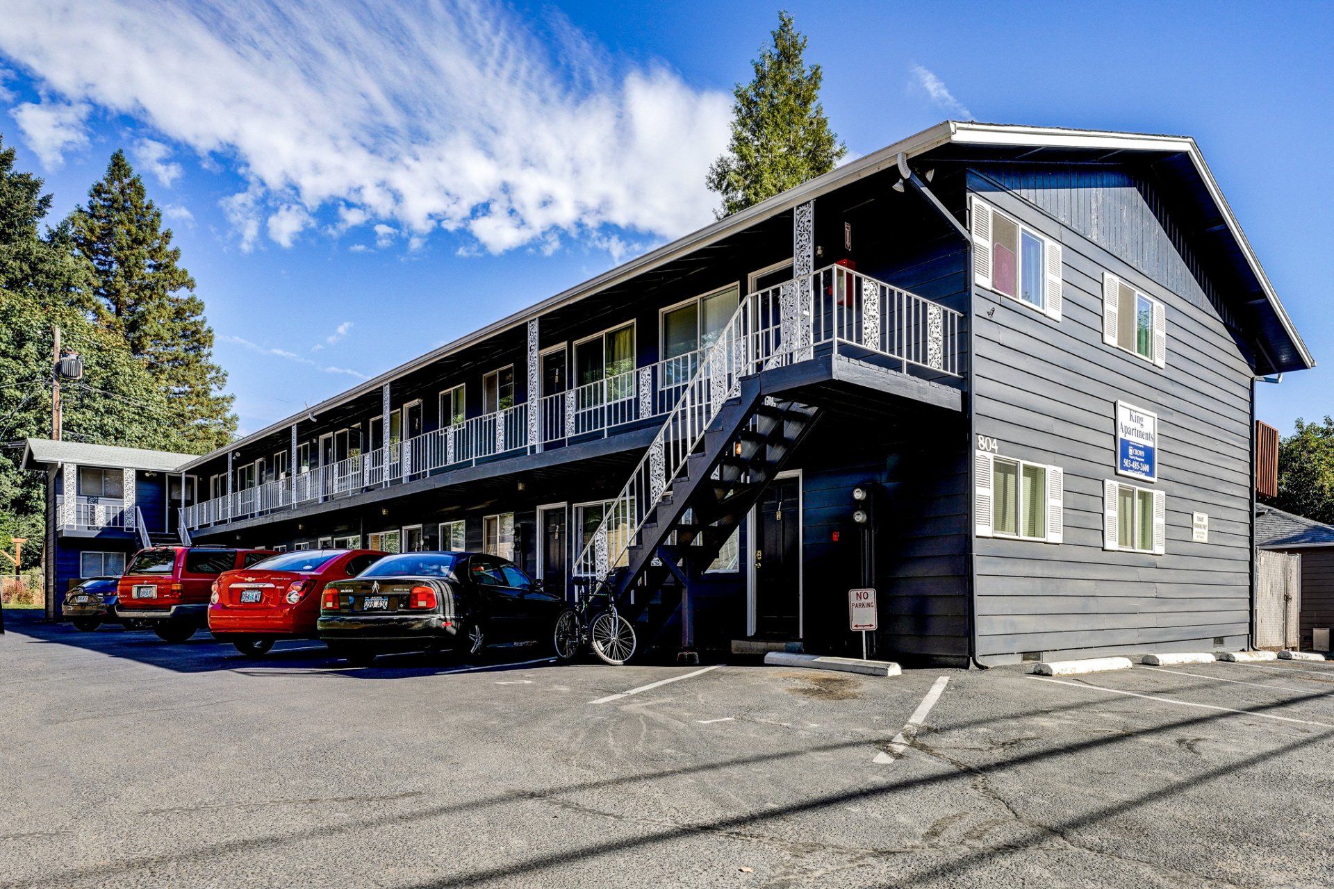 A large apartment building with cars parked in front of it