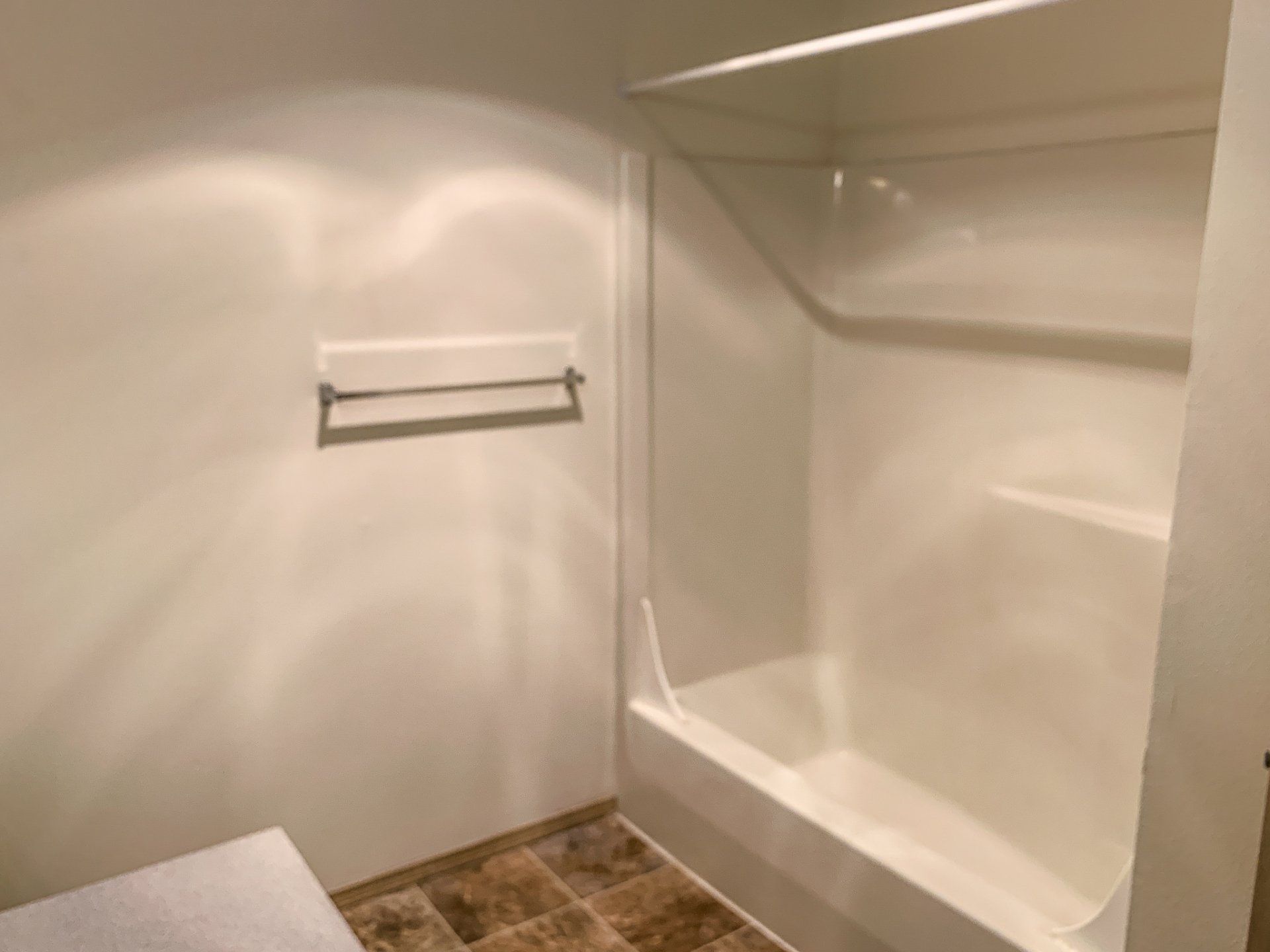 A bathroom with a bathtub and a towel rack.