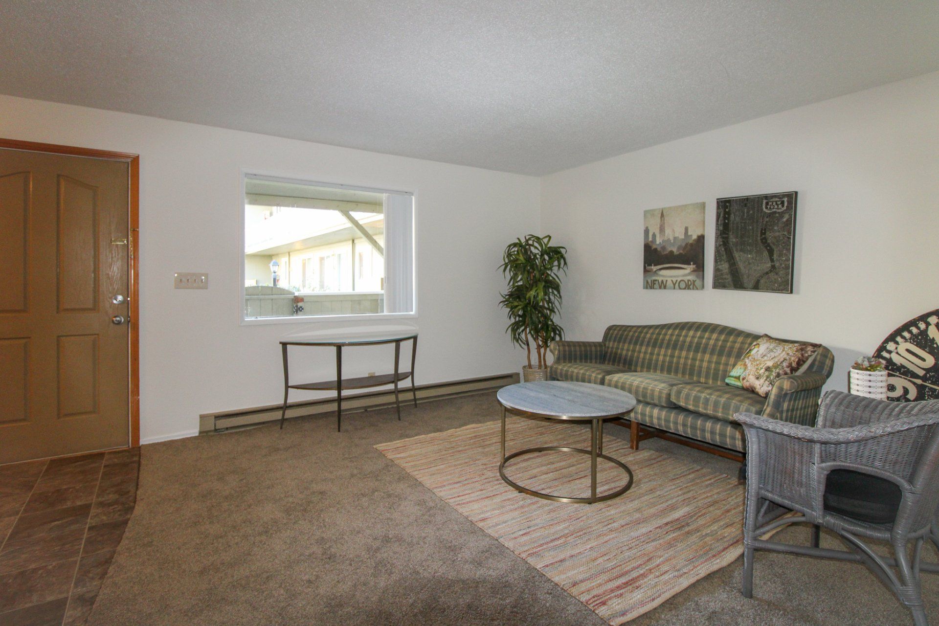 A living room with a couch , chair , table and window.