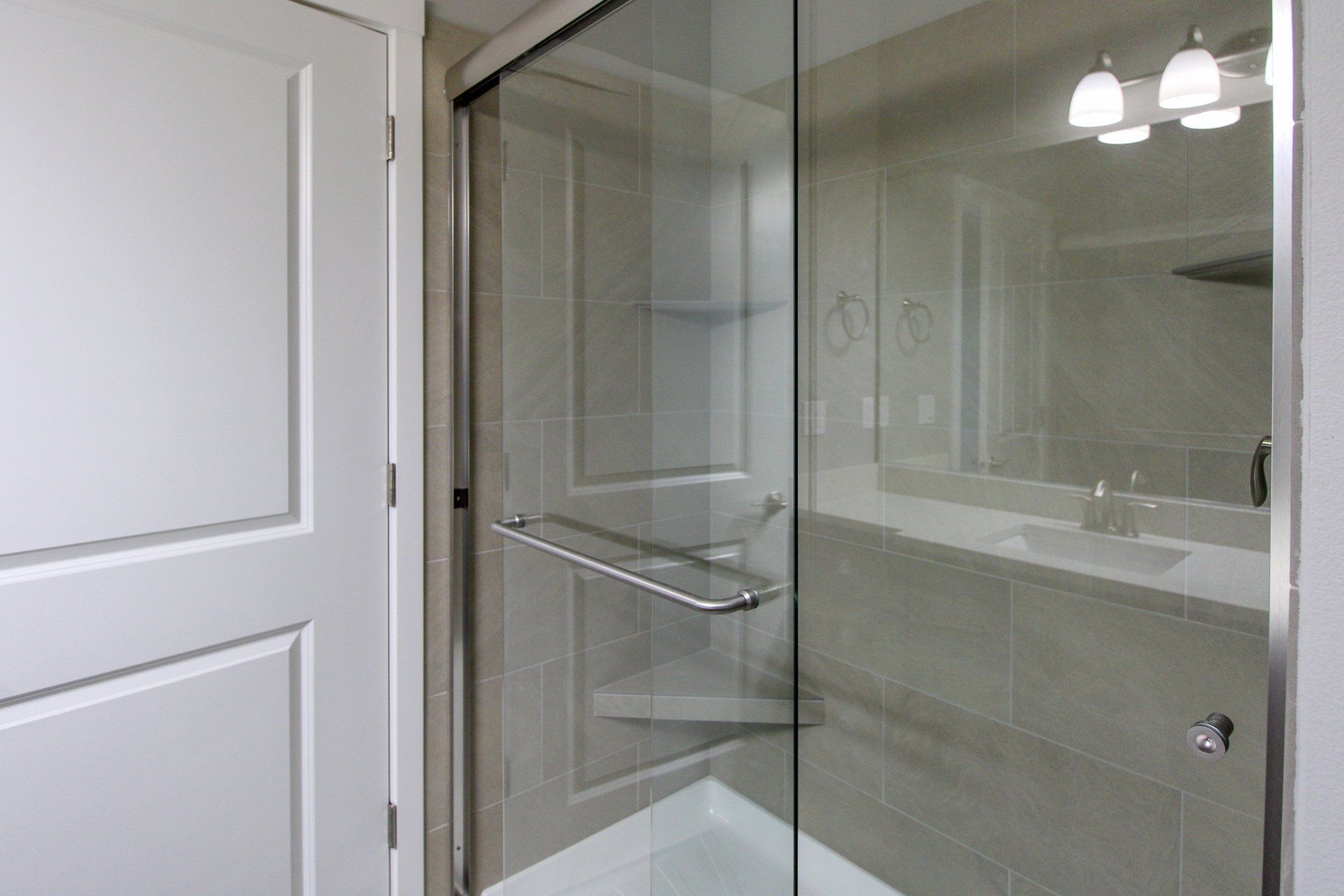 A bathroom with a walk in shower and a sink.