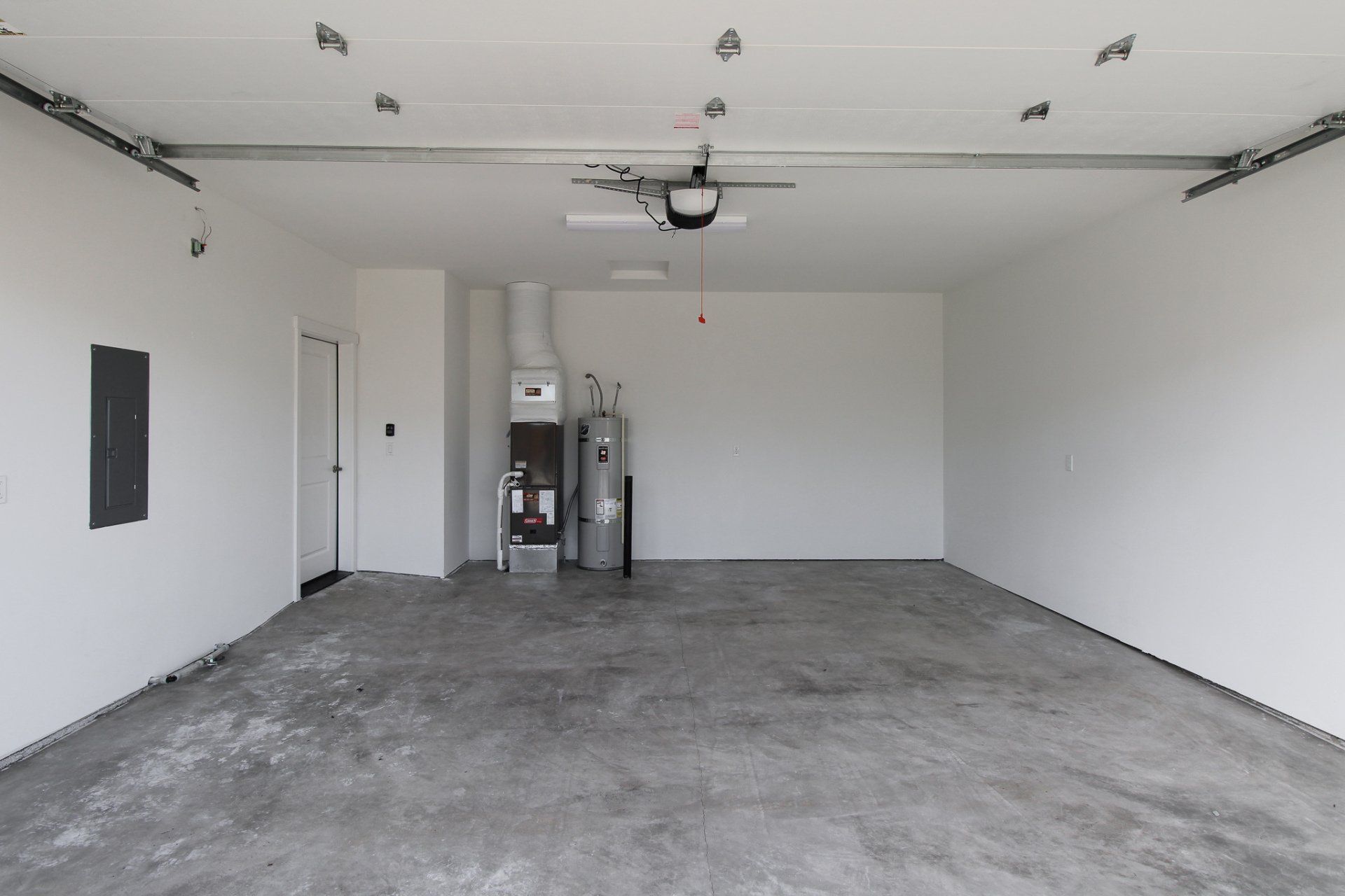An empty garage with a concrete floor and white walls.