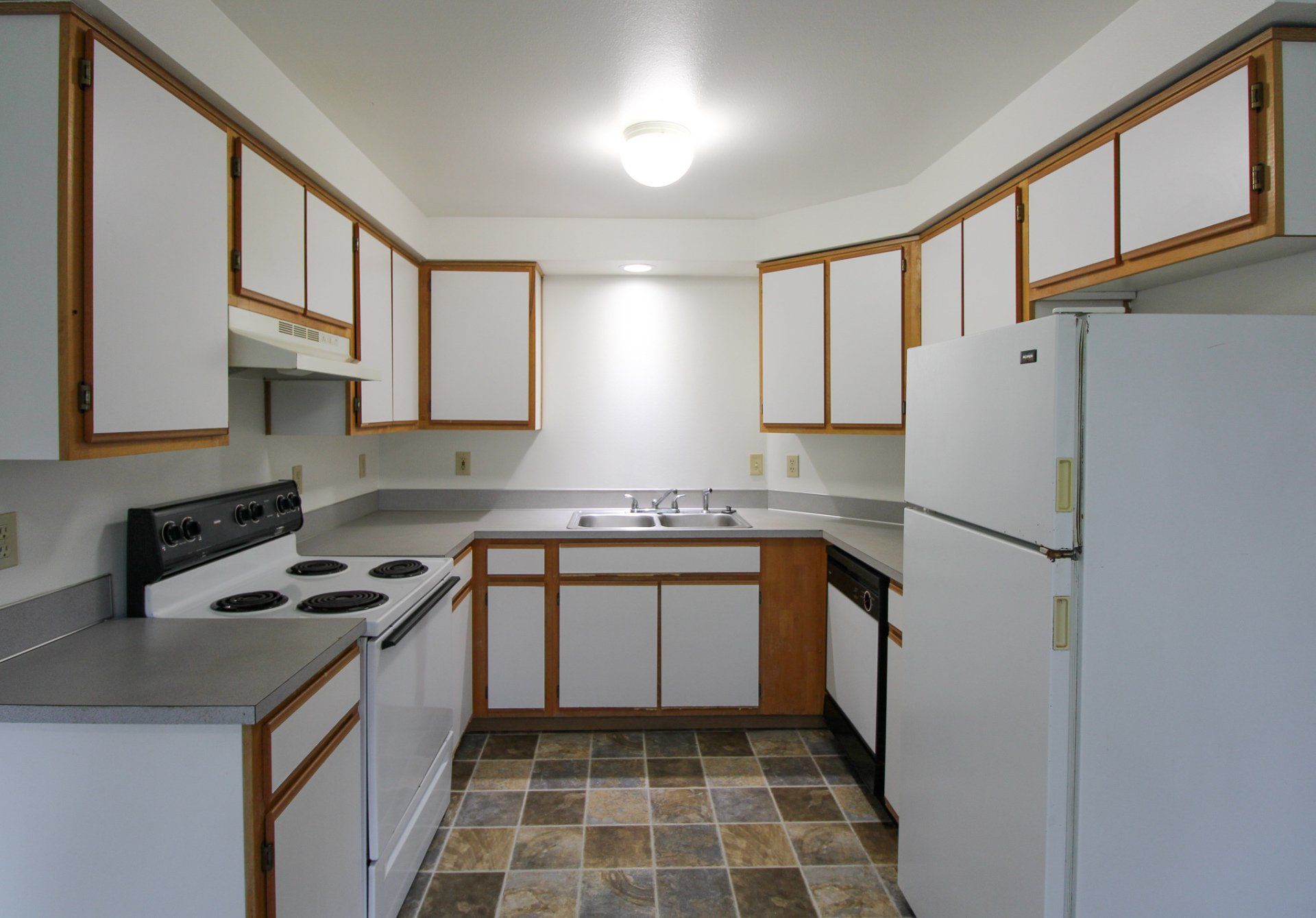 A kitchen with white cabinets and a white refrigerator