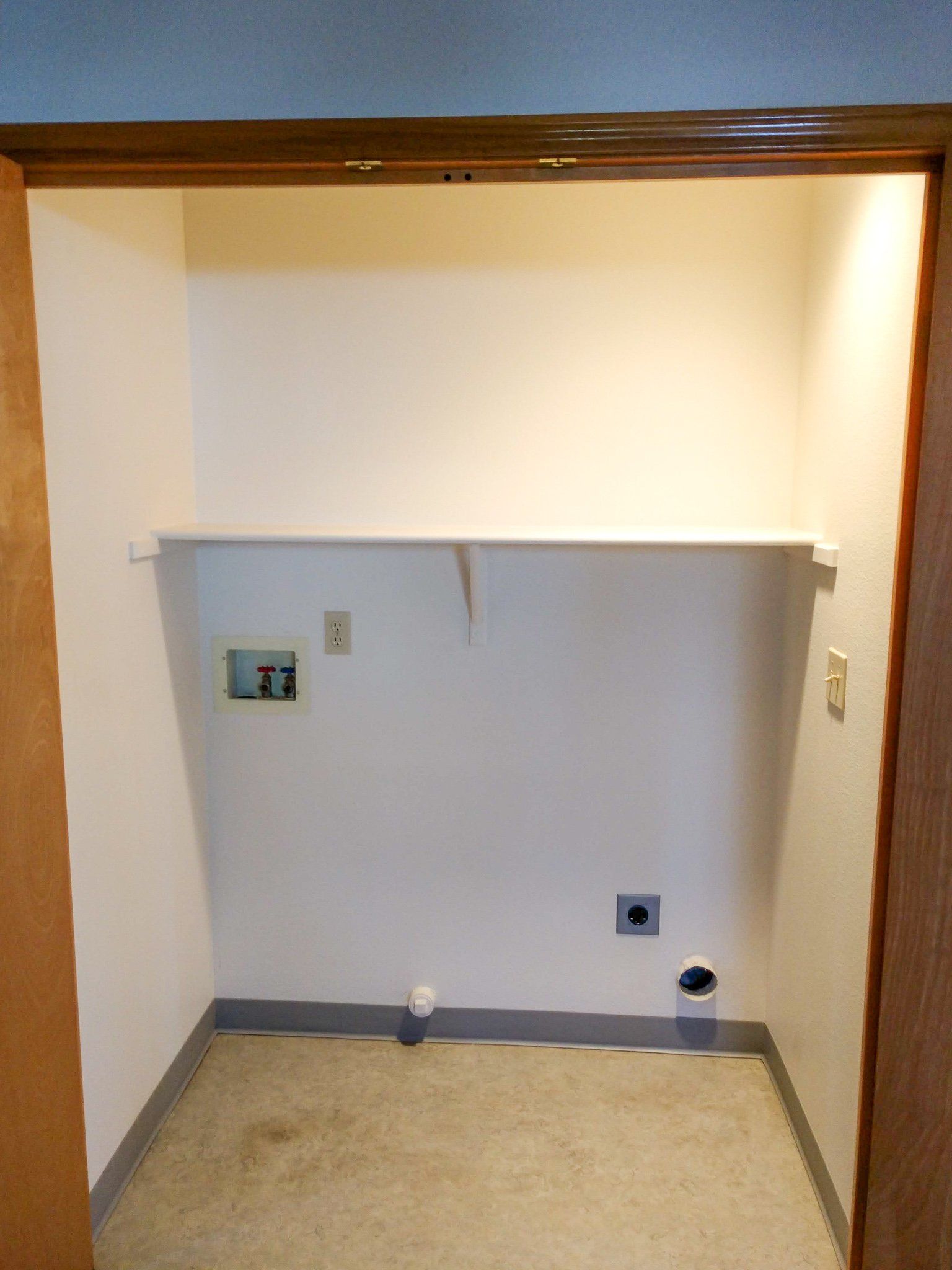 A small room with a shelf on the wall
