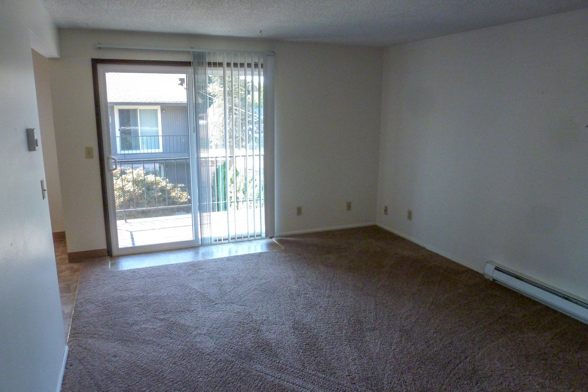 An empty living room with a sliding glass door