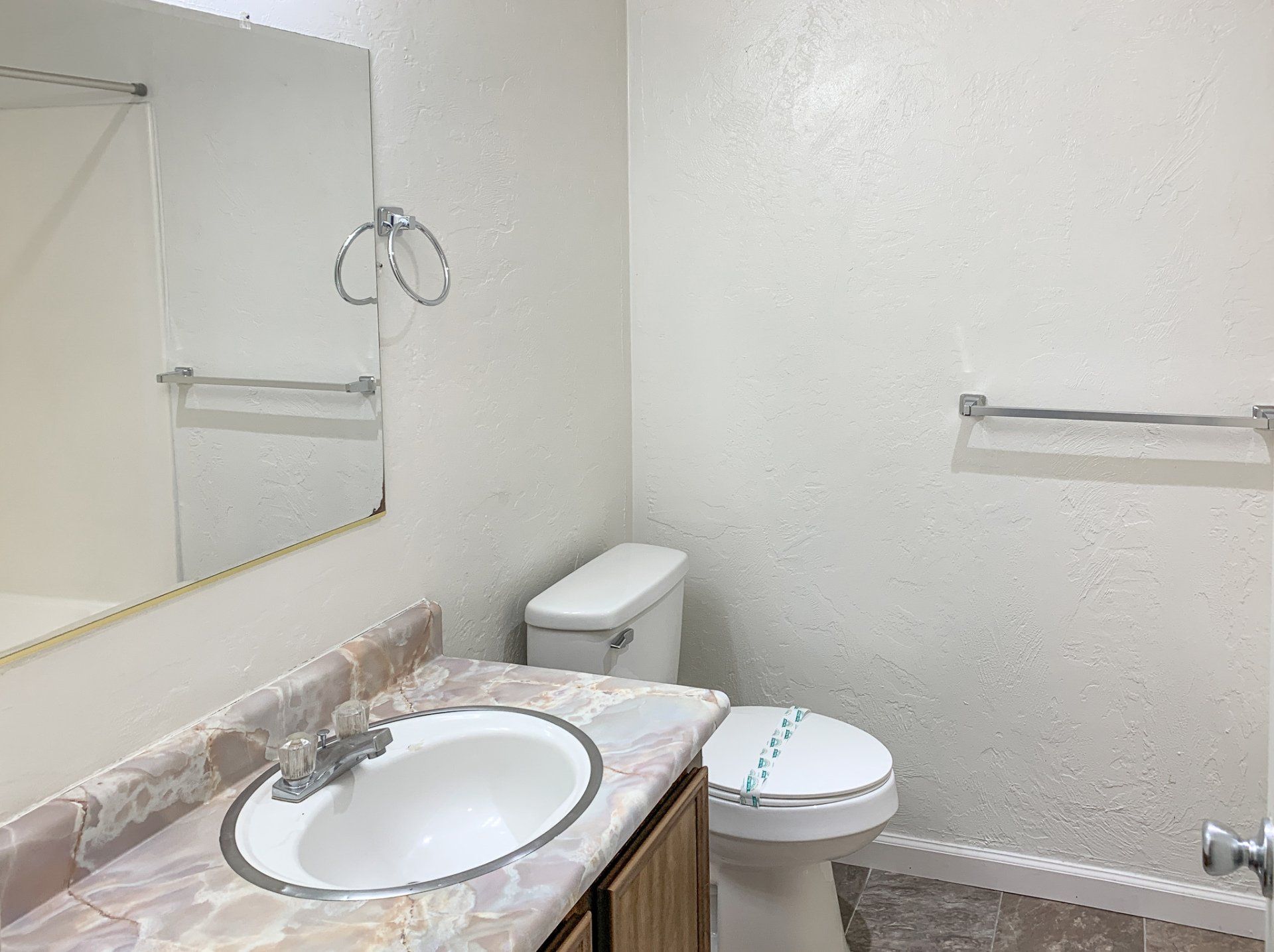 A bathroom with a sink , toilet and mirror.