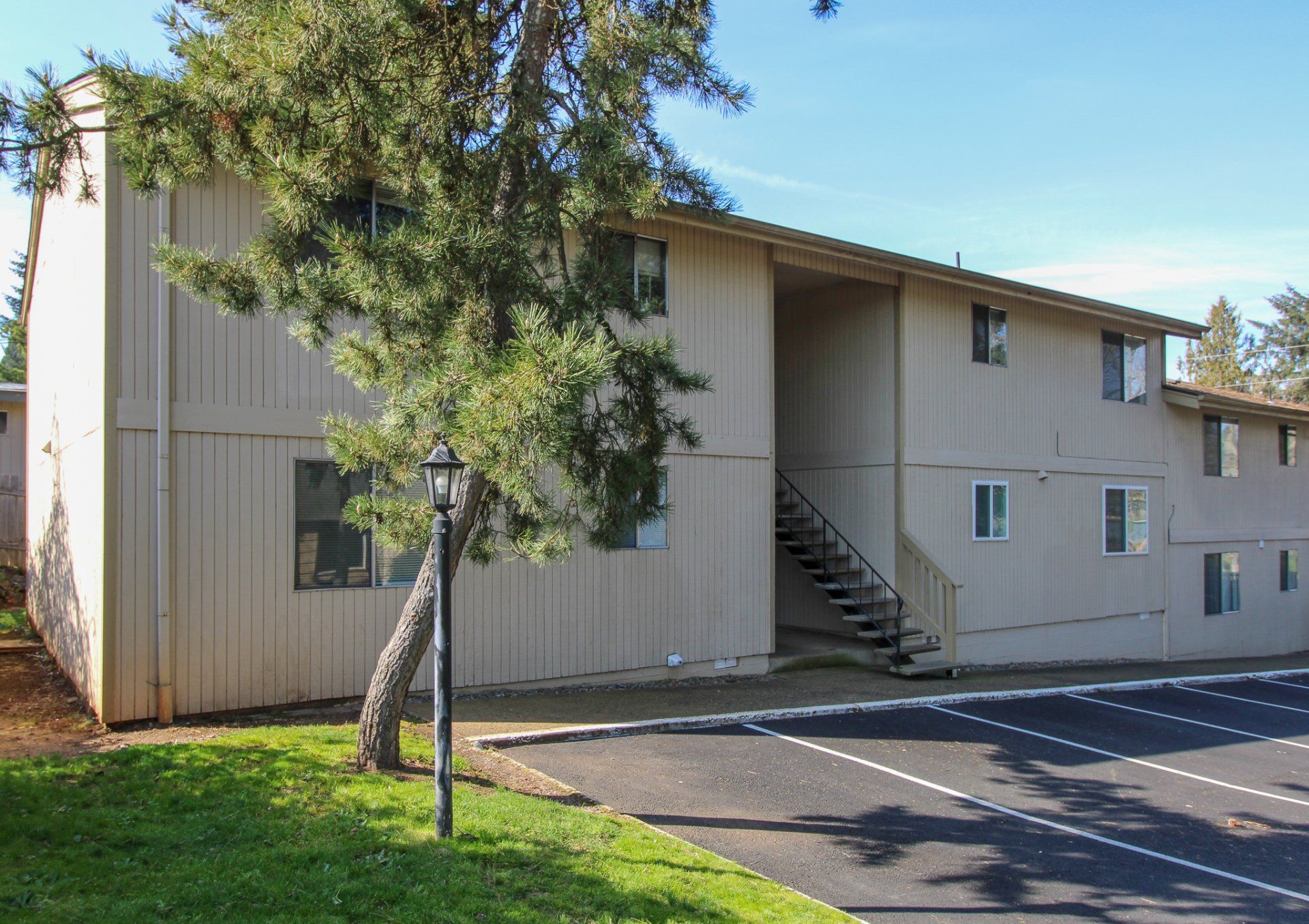 A large apartment building with stairs and a tree in front of it
