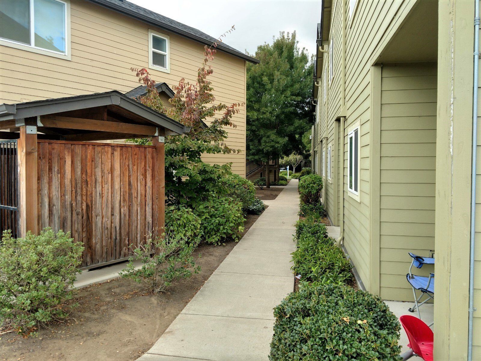 A walkway between two buildings with a wooden fence