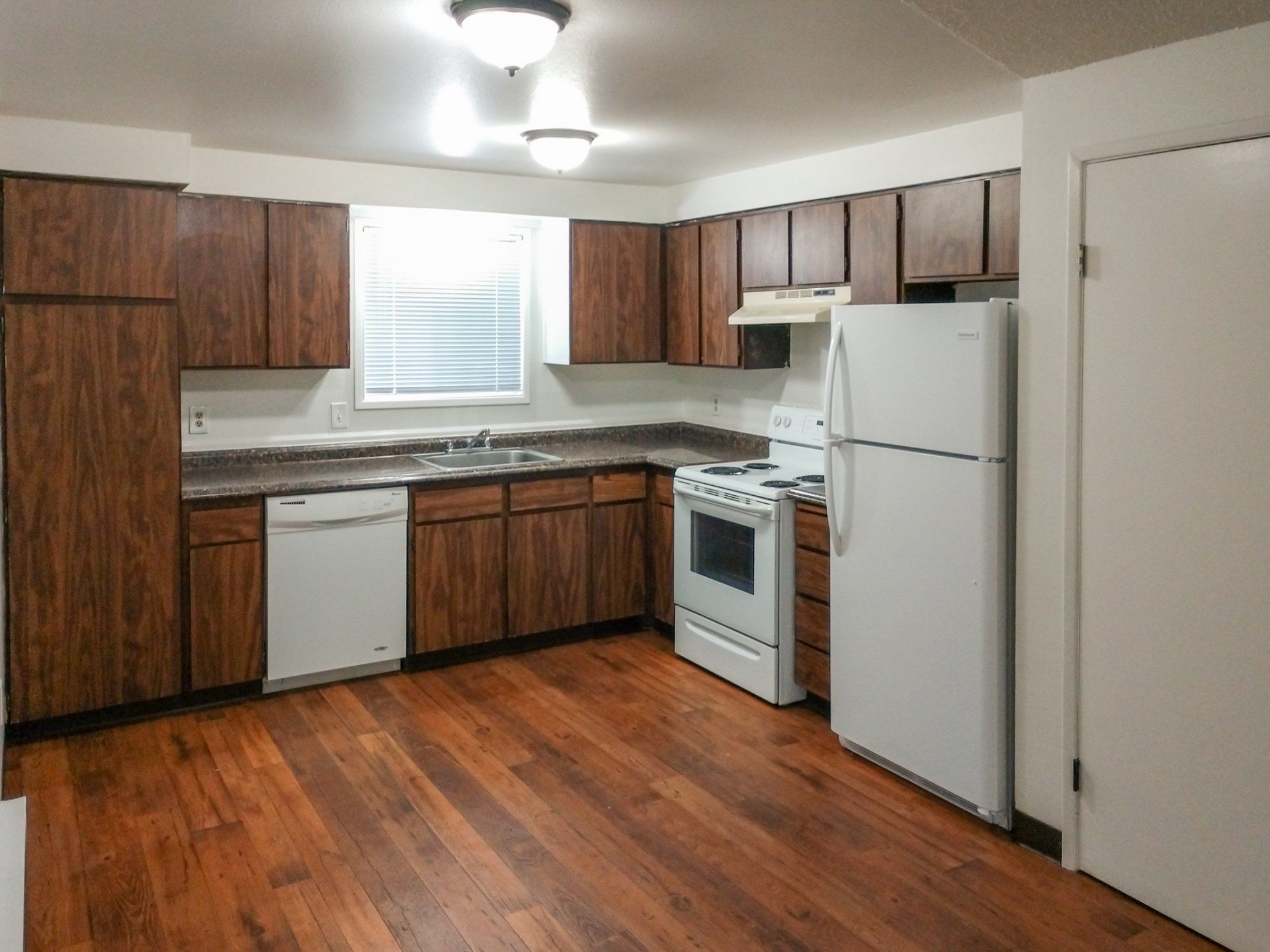 A kitchen with wooden cabinets and a white refrigerator
