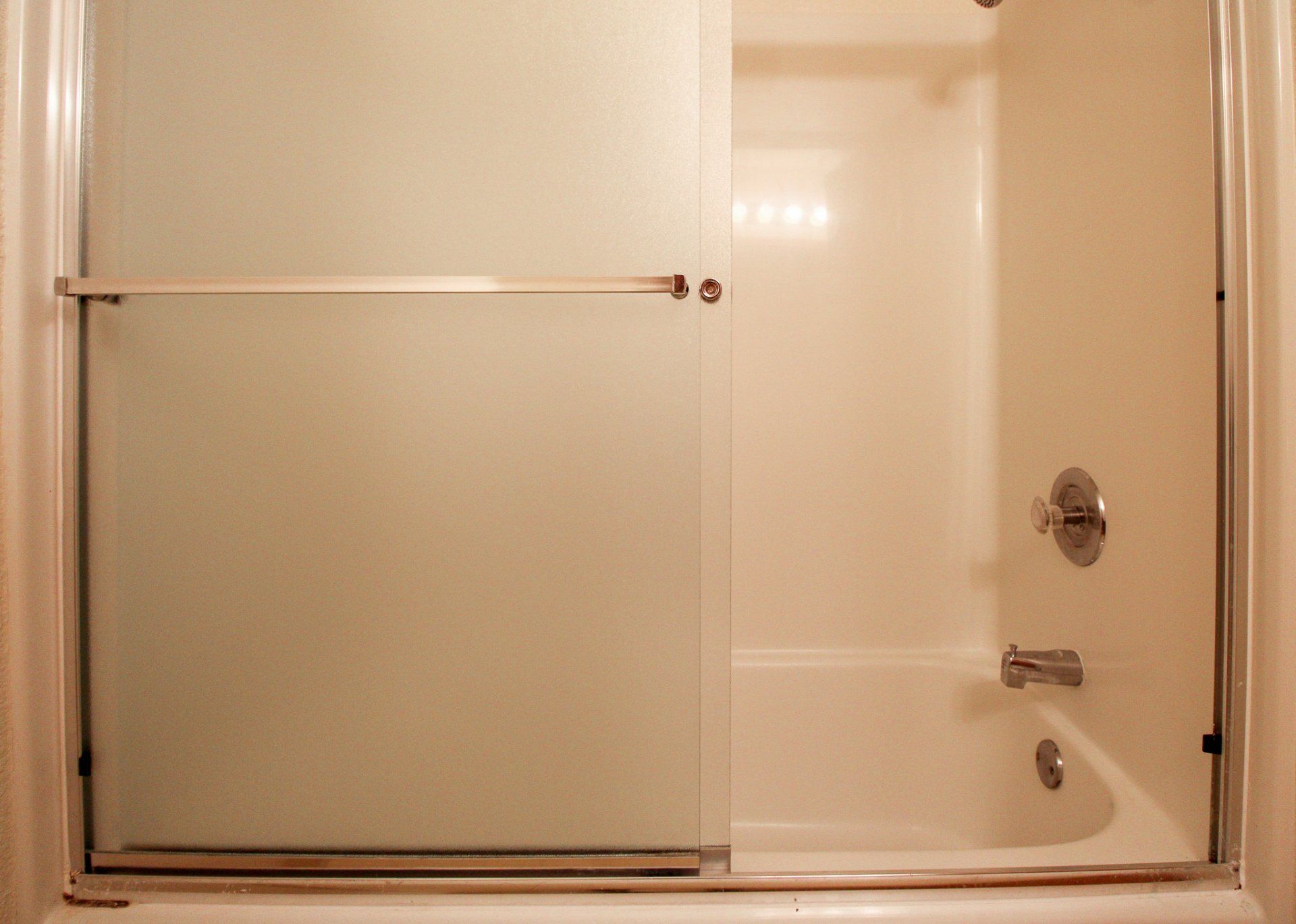 A bathroom with a bathtub and a sliding glass shower door.