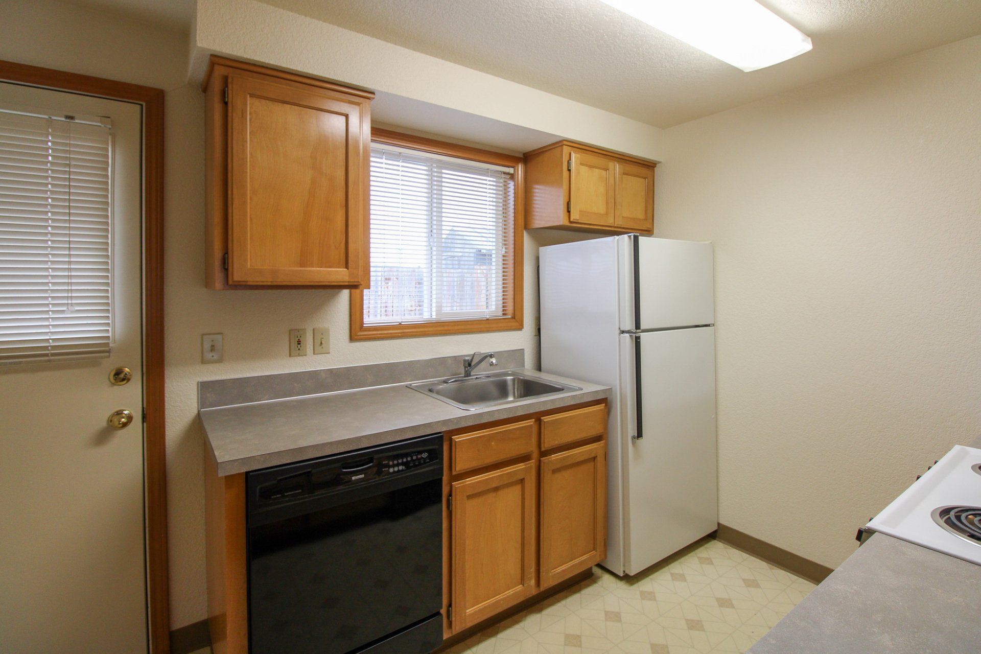A kitchen with a refrigerator , sink , stove and dishwasher