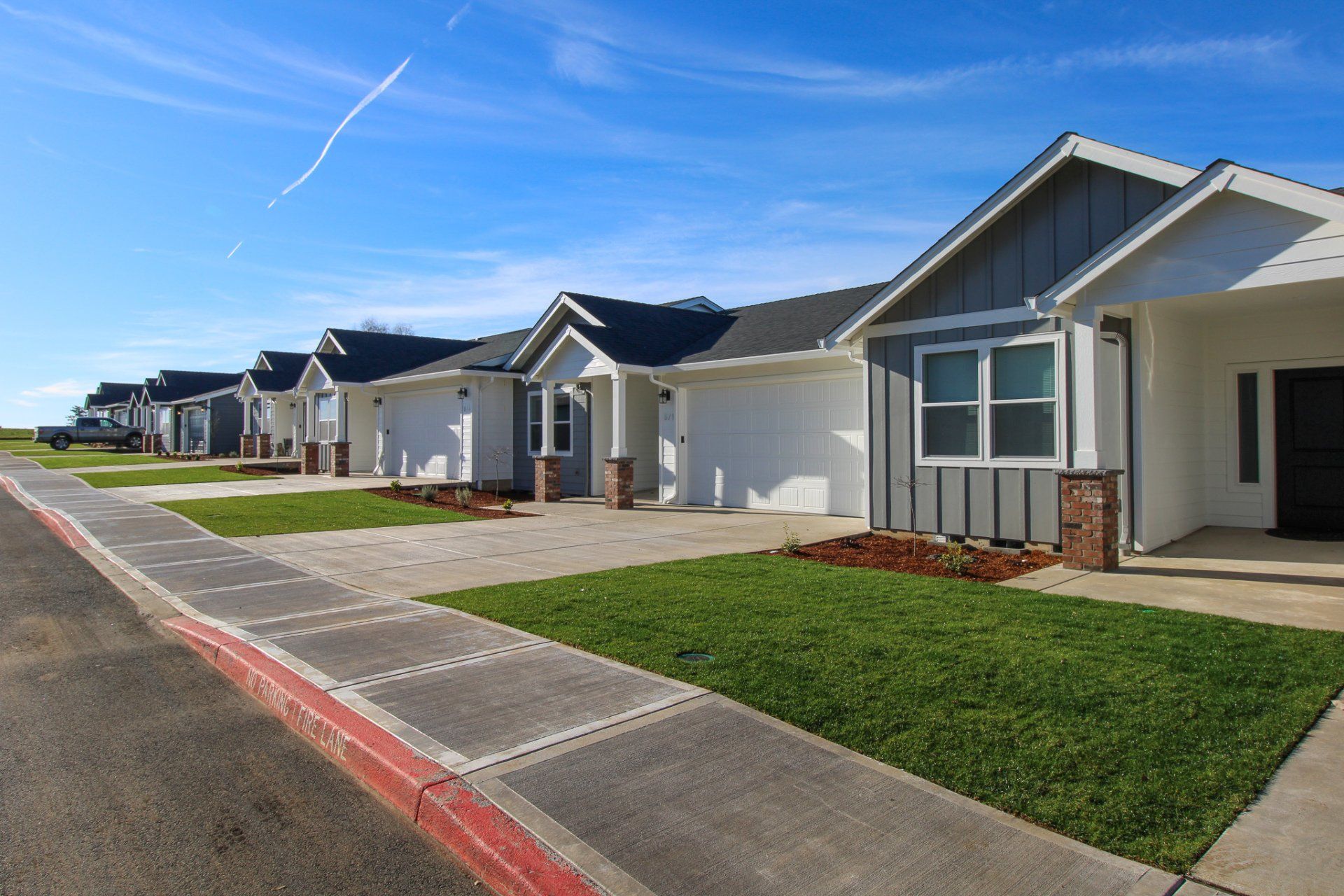 A row of houses are lined up next to each other on a sunny day.