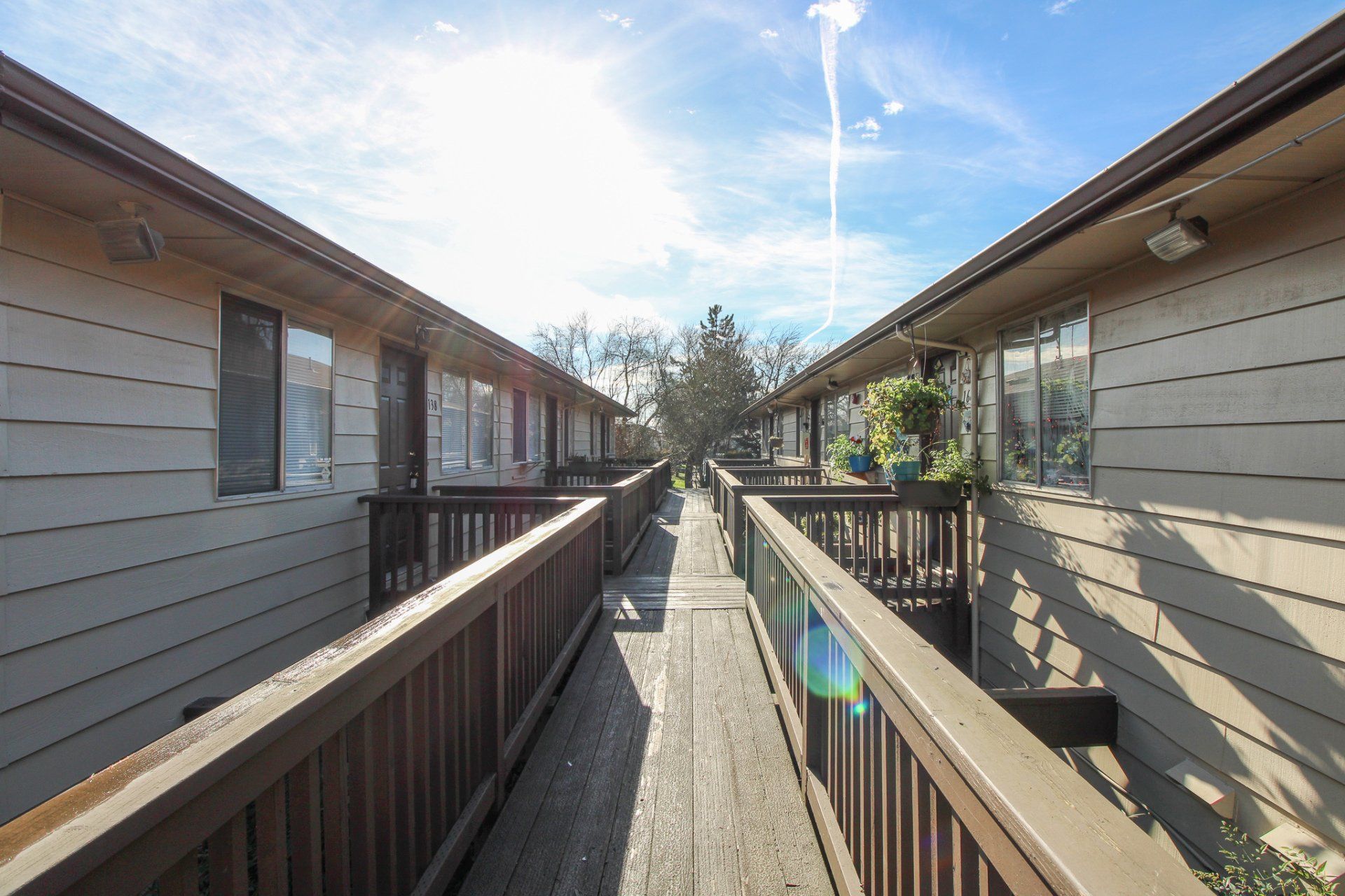 A walkway between two buildings with a wooden railing