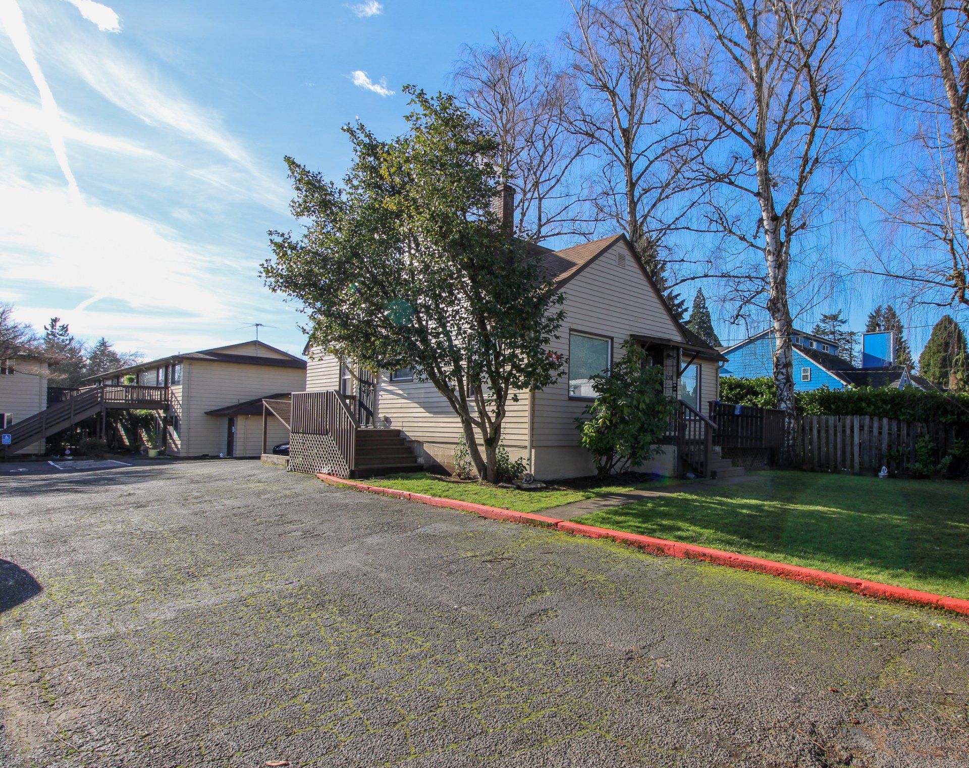 A small house with a gravel driveway in front of it