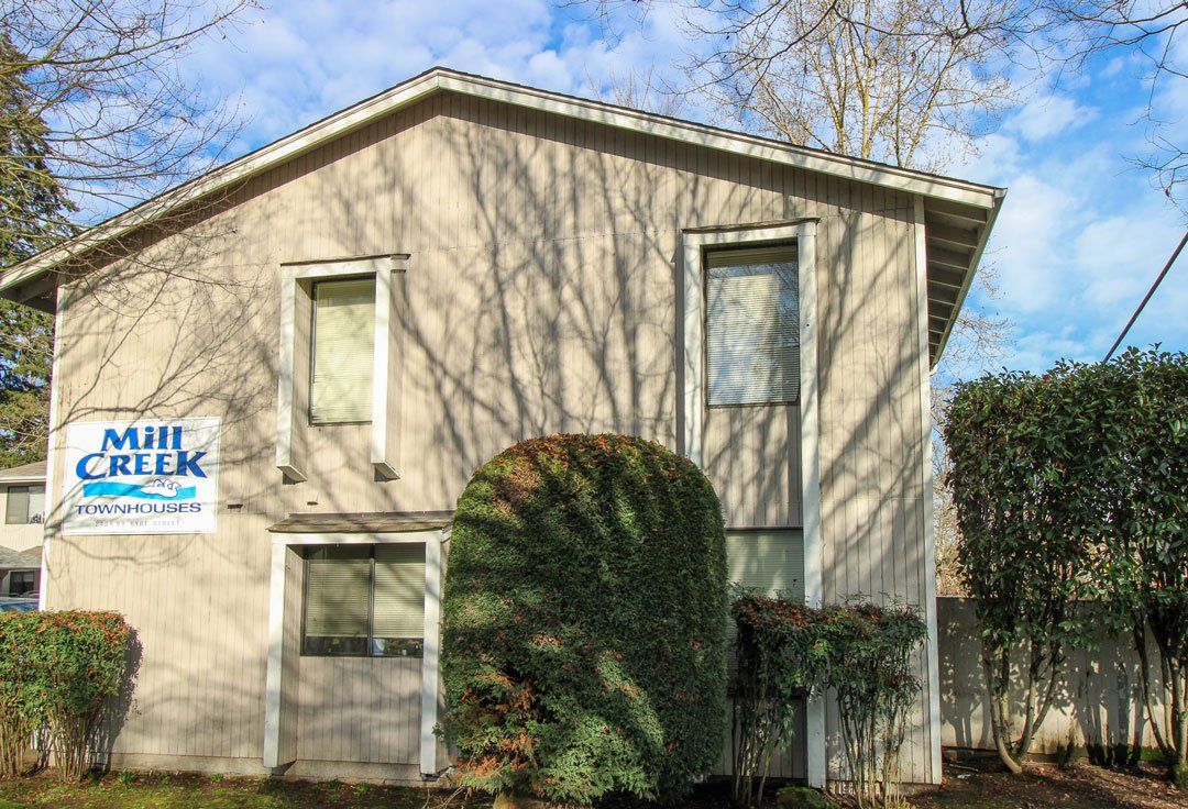 A small house with a sign on the side that says mill creek.