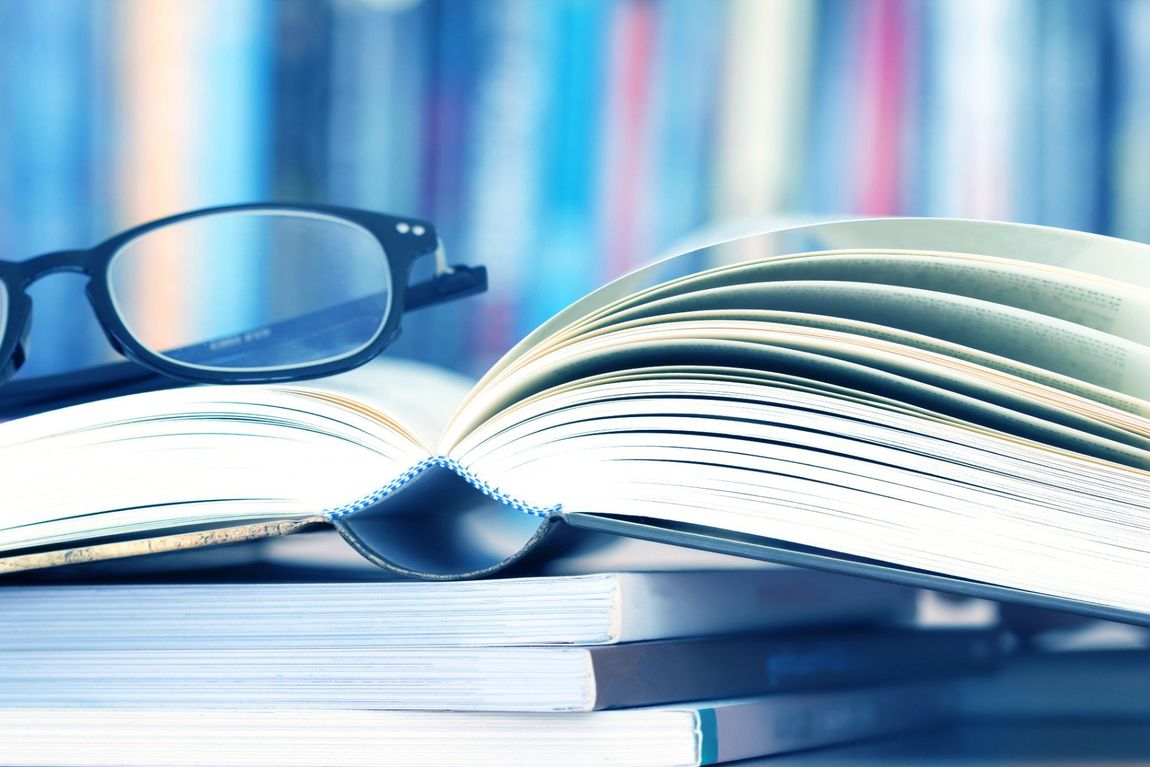 occhiali appoggiati su una serie di libri