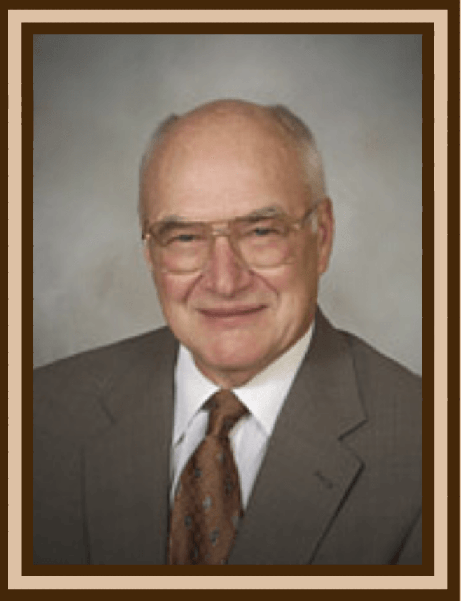 A man in a suit and tie is smiling for the camera