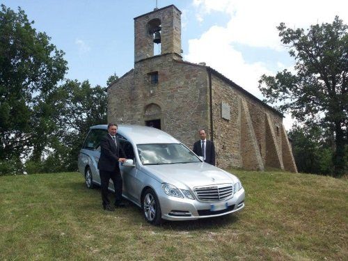 Due uomini vicino a un carro funebre