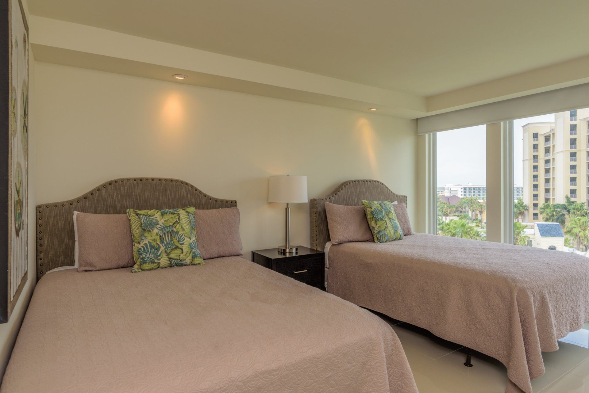 Una habitación de hotel con dos camas y una gran ventana.