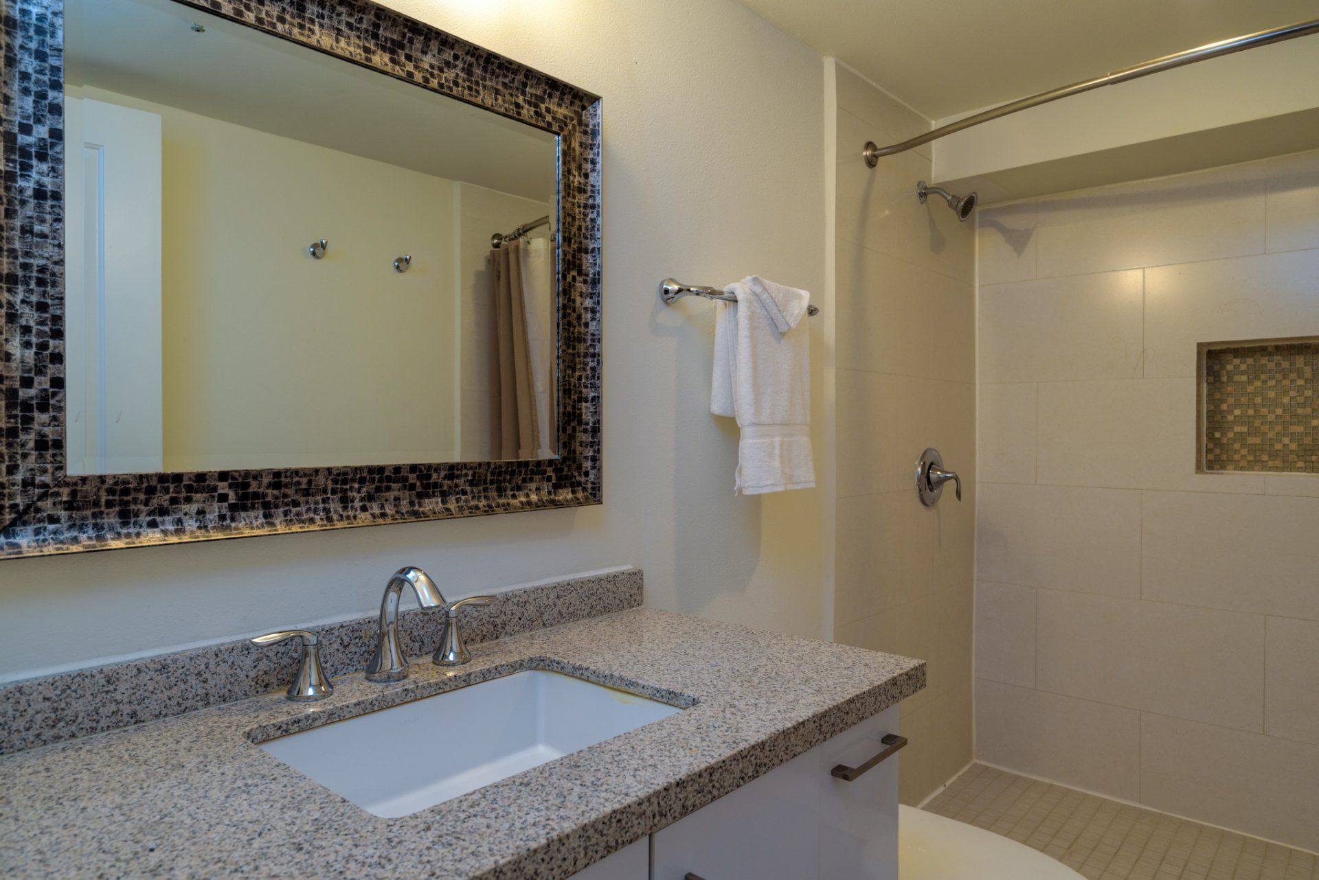 Un baño con lavabo, espejo, inodoro y ducha.