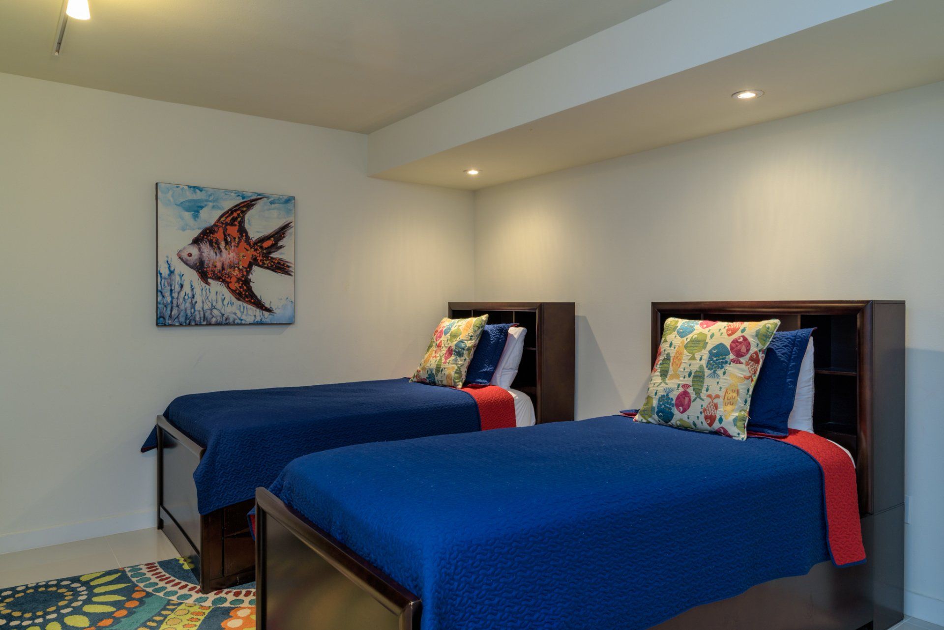 Un dormitorio con dos camas y un cuadro de un pez en la pared.