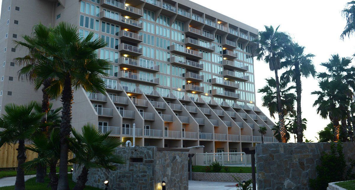 Un gran edificio con palmeras delante.
