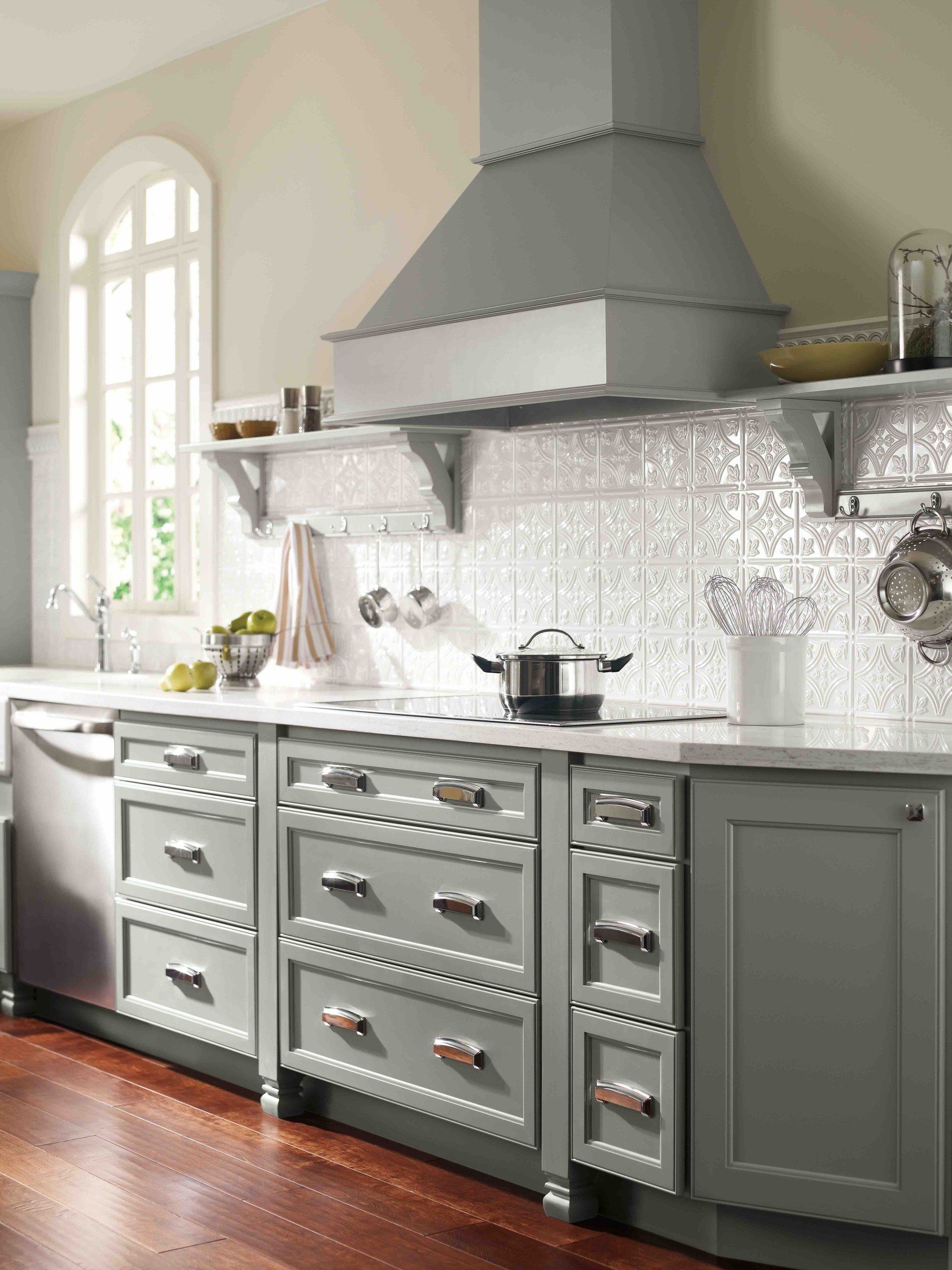 A kitchen with gray cabinets and stainless steel appliances