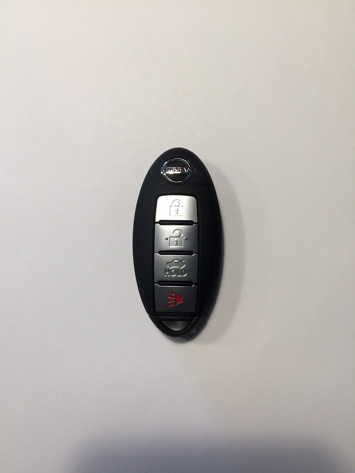 Black Nissan car key fob with buttons against a white background.