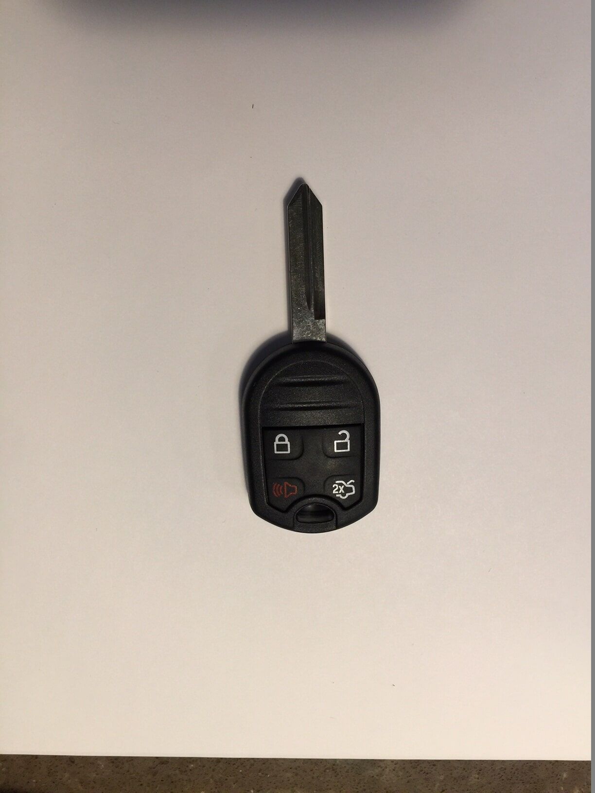 Ford car key with black remote, showing lock, unlock, and panic buttons.