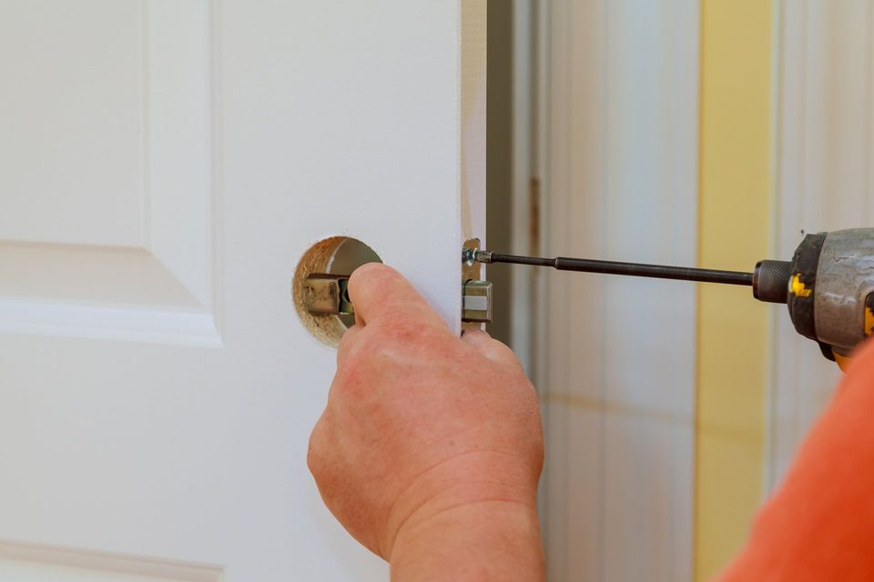 Locksmith — Hands Changing Doorknob Of A Door in Philadelphia, PA Locksmith — Hands Changing Doorknob Of A Door in Philadelphia, PA