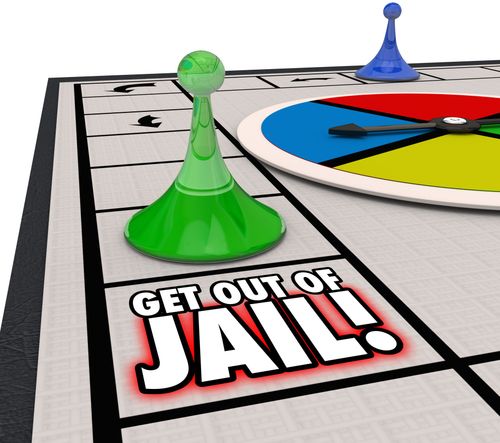Monopoly board with a green pawn on “Get Out of Jail” and a blue pawn near the spinner.