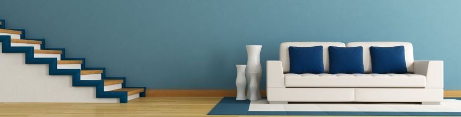 White couch in front of blue wall