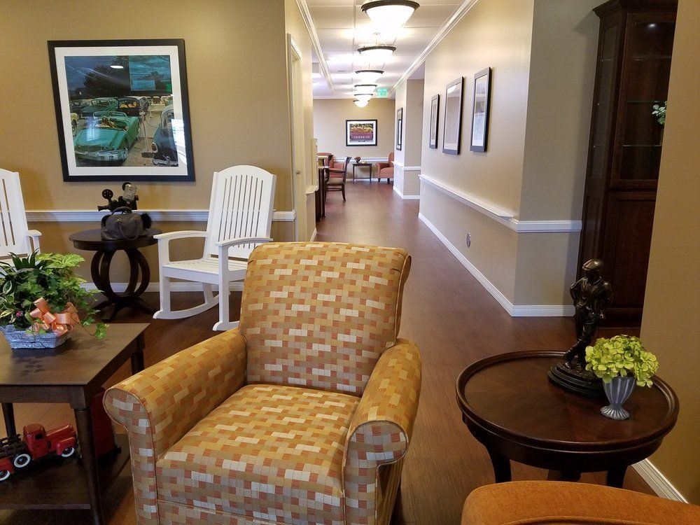 Interior hallway with chairs, artwork, and warm lighting.