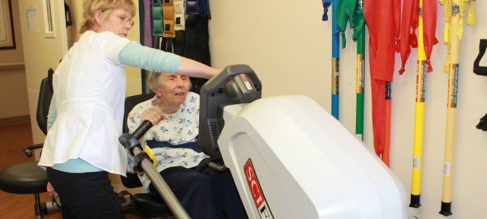 Elderly woman excising with nurse on a rehabilitation machine Elderly woman excising on a rehabilitation machine in Artesia, CA.