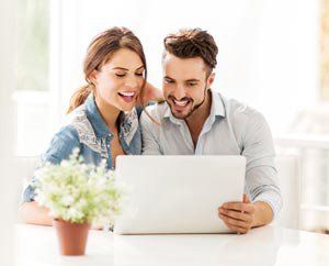 A couple looks at a laptop computer.