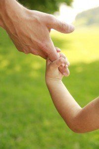 Baby holding hands with parent