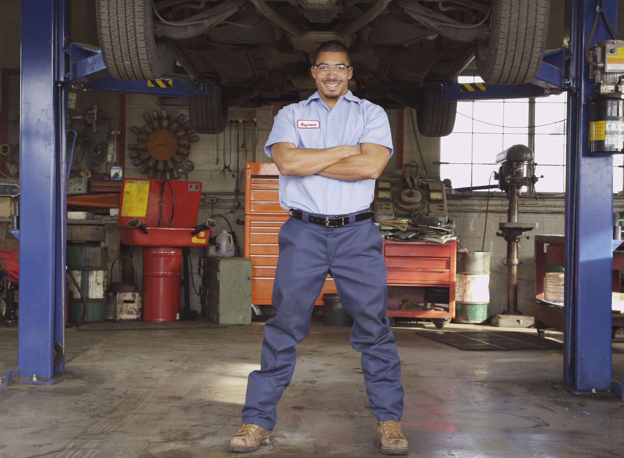 Honest, professional auto mechanic smiles at customers