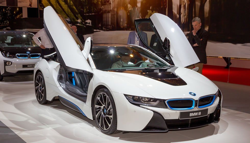 White BMW i8 with doors open, on display at an event.