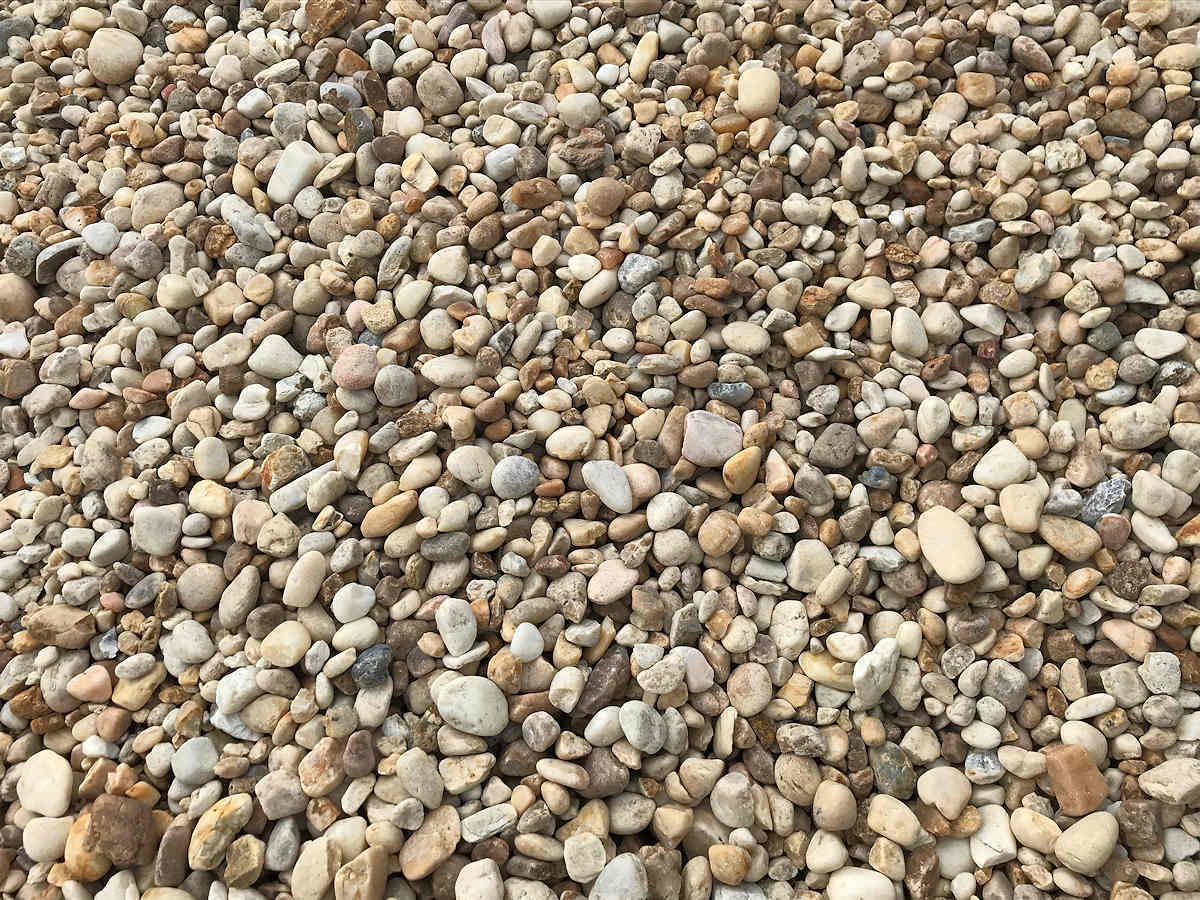 Pile of small, rounded beige and tan gravel rocks.