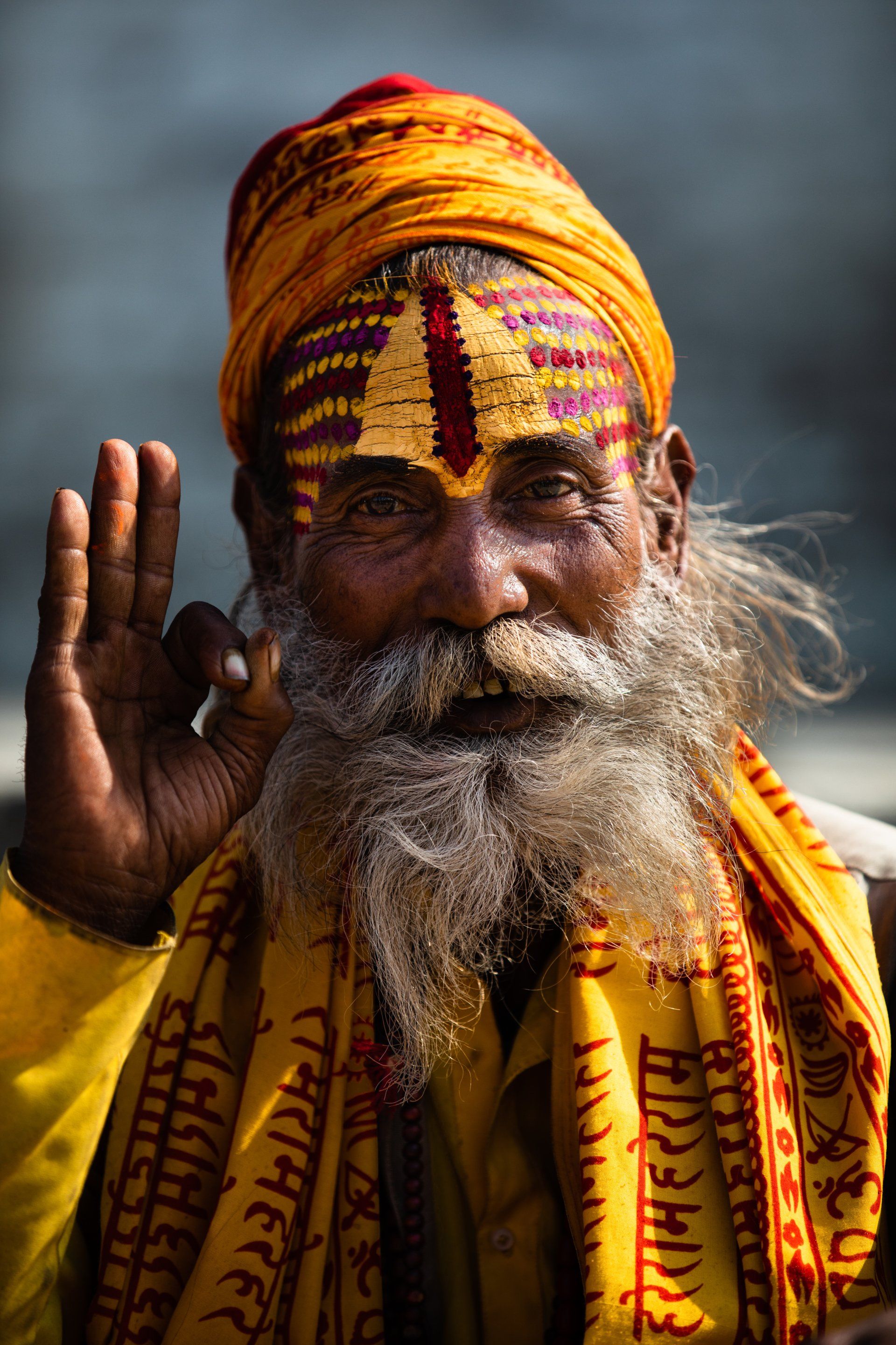 A man with a beard and a turban on his head is waving his hand.