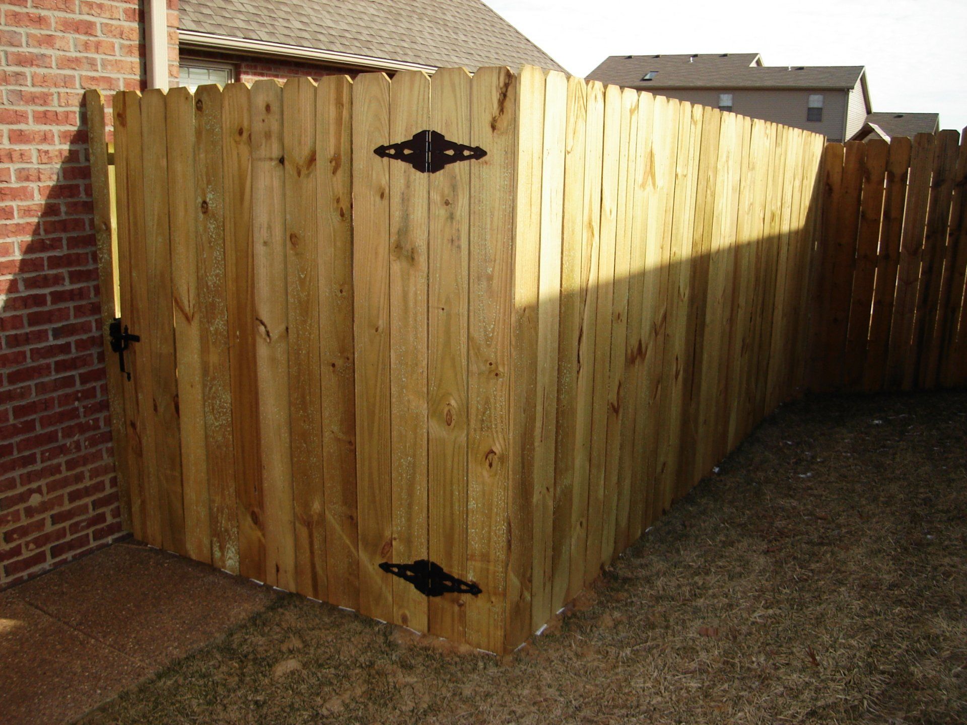 A wooden fence with a gate in the backyard