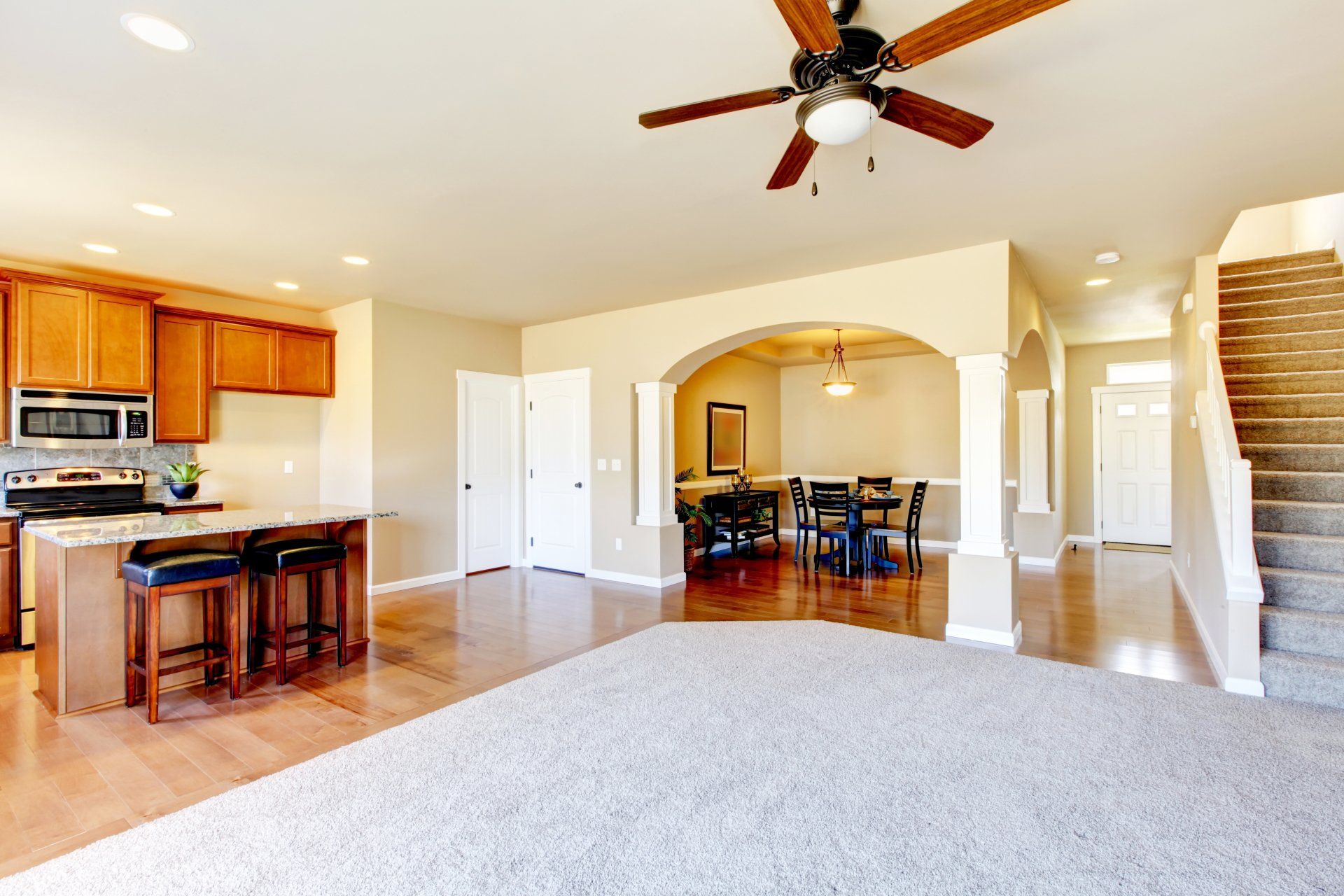 A kitchen and dining room in a house with a ceiling fan