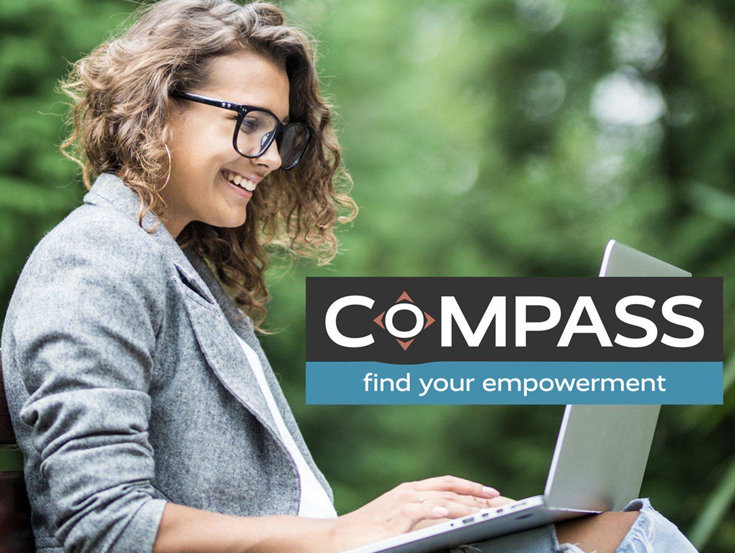 Woman using laptop, smiling outdoors. Compass logo: 