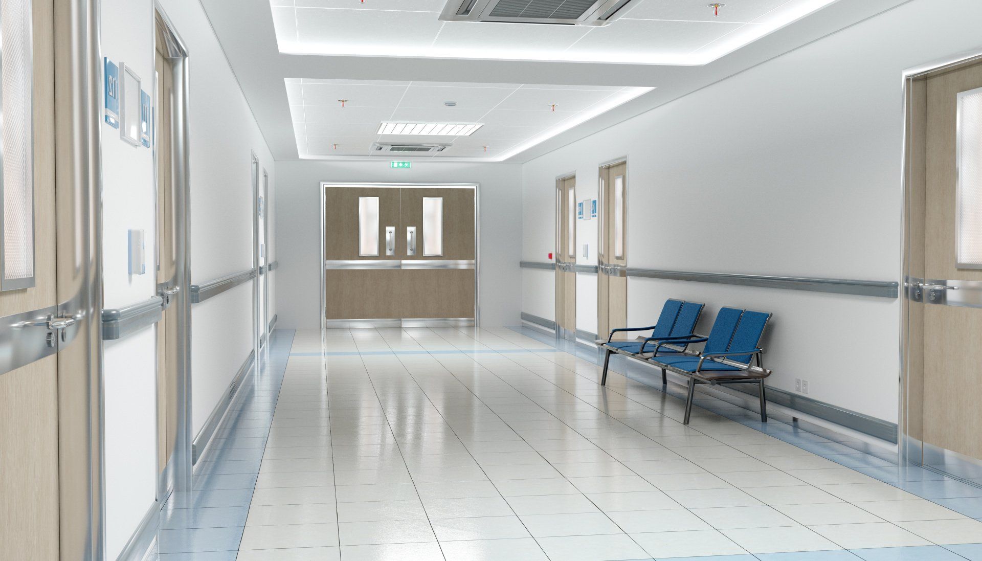 An empty hospital hallway with chairs and doors.