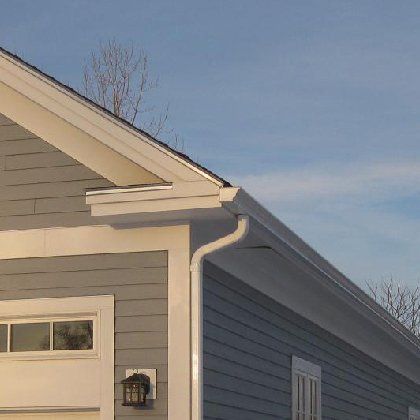 A gray house with a white garage door and gutter