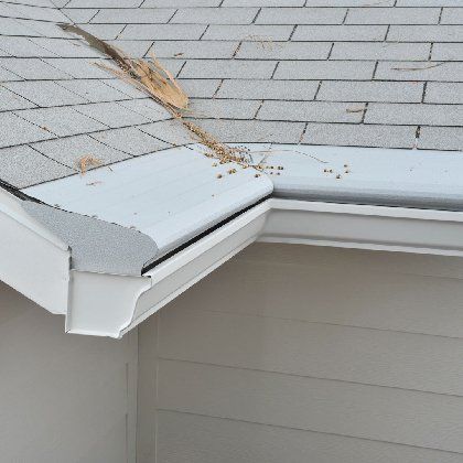 A gutter on the side of a house with a broken roof